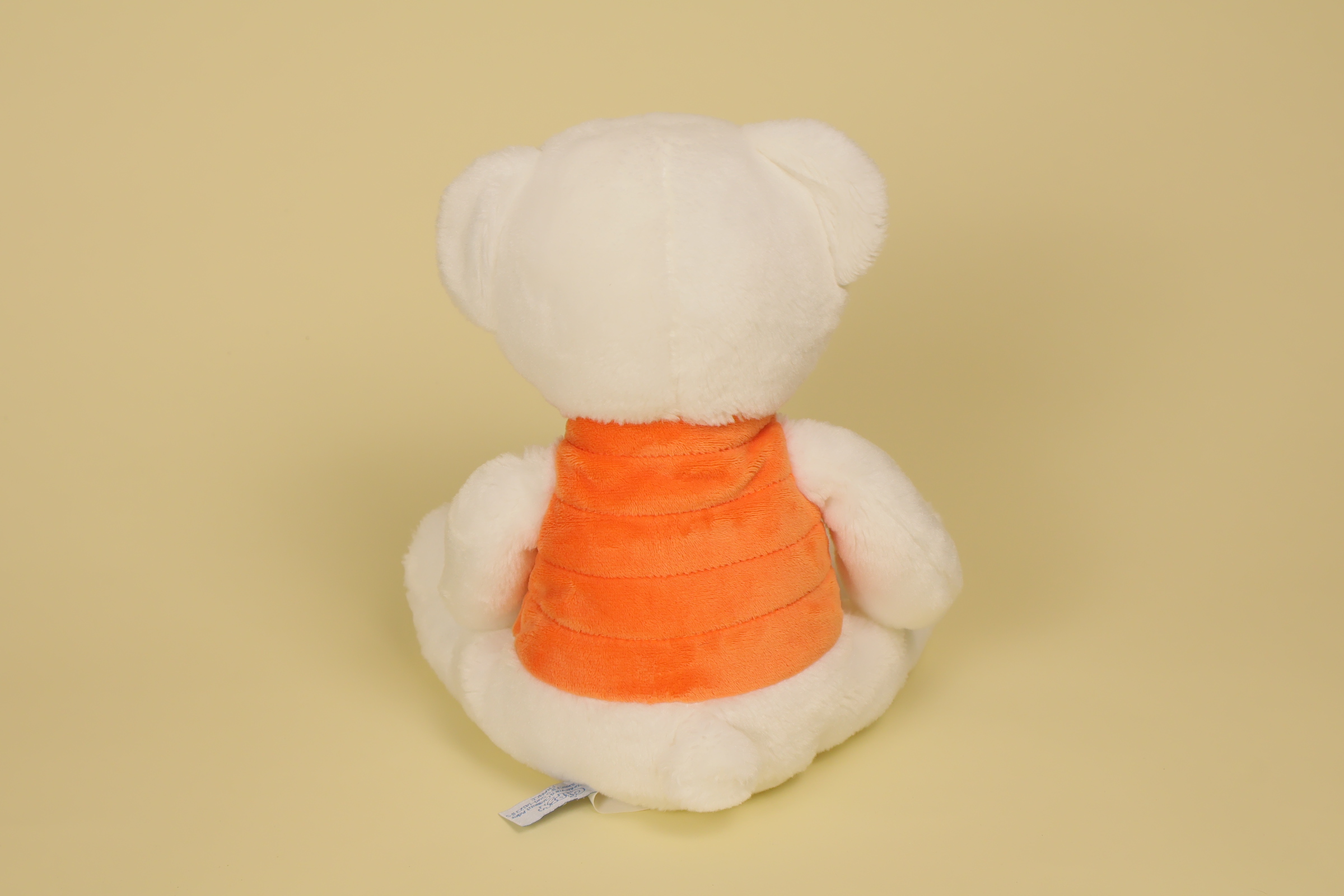 dos Peluche ours blanc 24 cm avec doudoune orange sans manche marque Gipsy doudou original