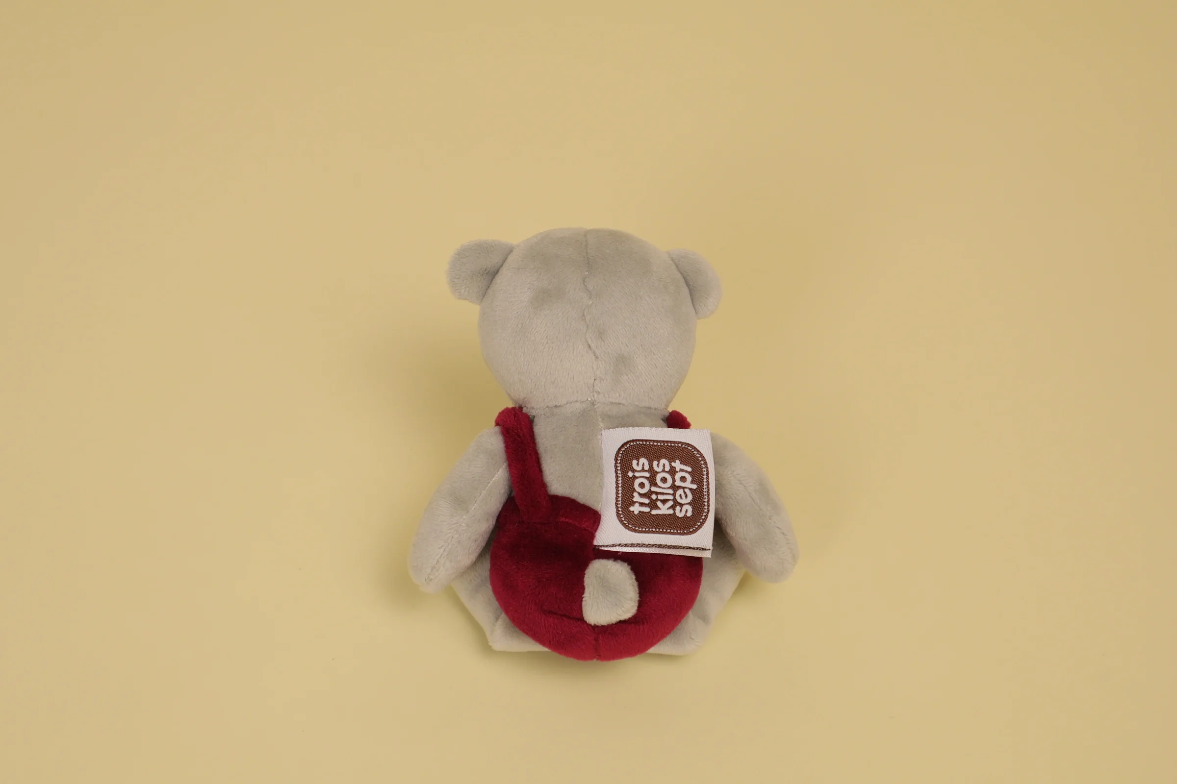 Dos Mini doudou ours gris 16 cm avec salopette et nœud papillon bordeaux marque Trois Kilos Sept