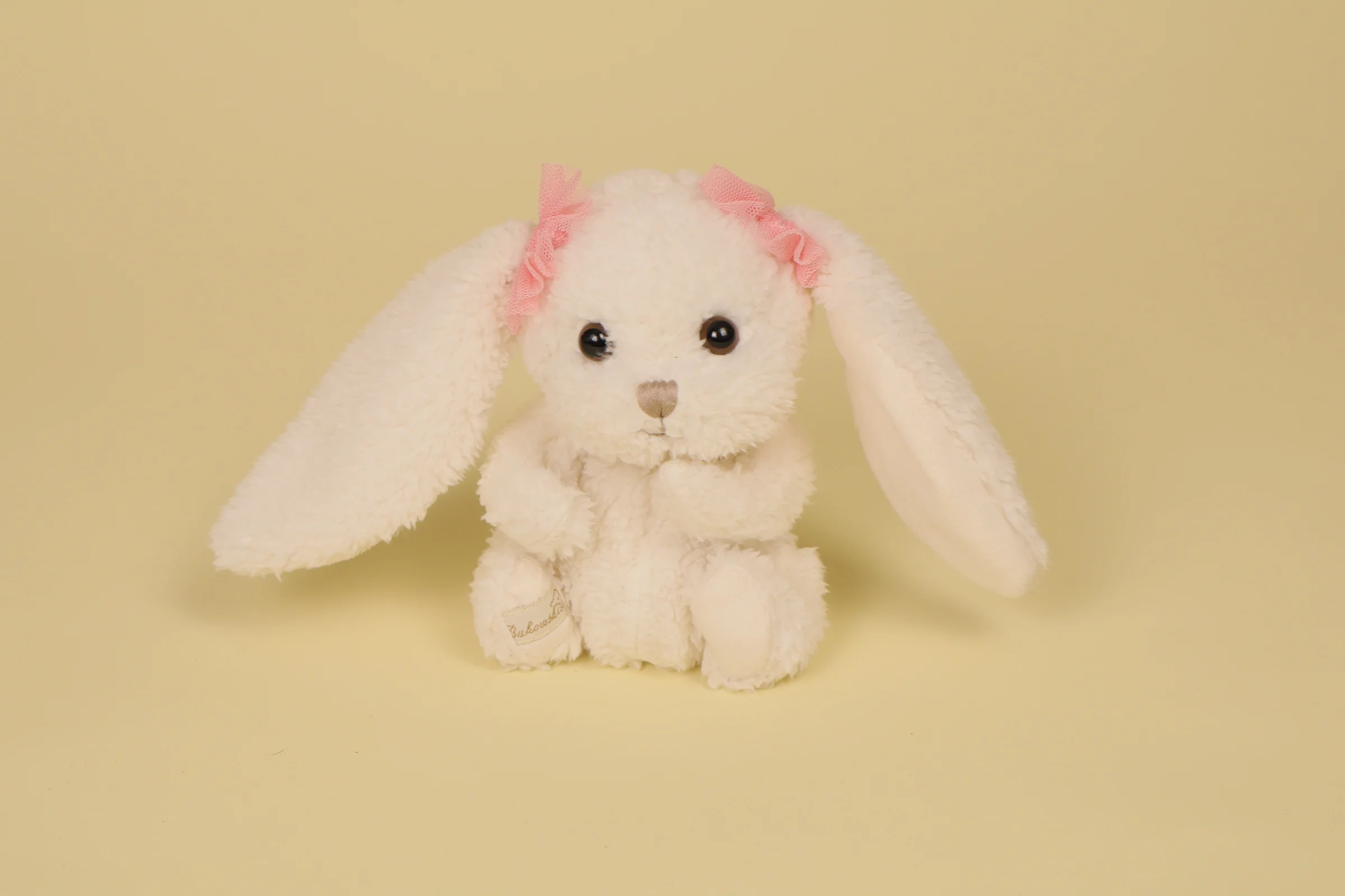 Mini peluche lapin blanc Alice 13 cm nœuds roses oreilles marque Bukowski Design doudou suédois naissance
