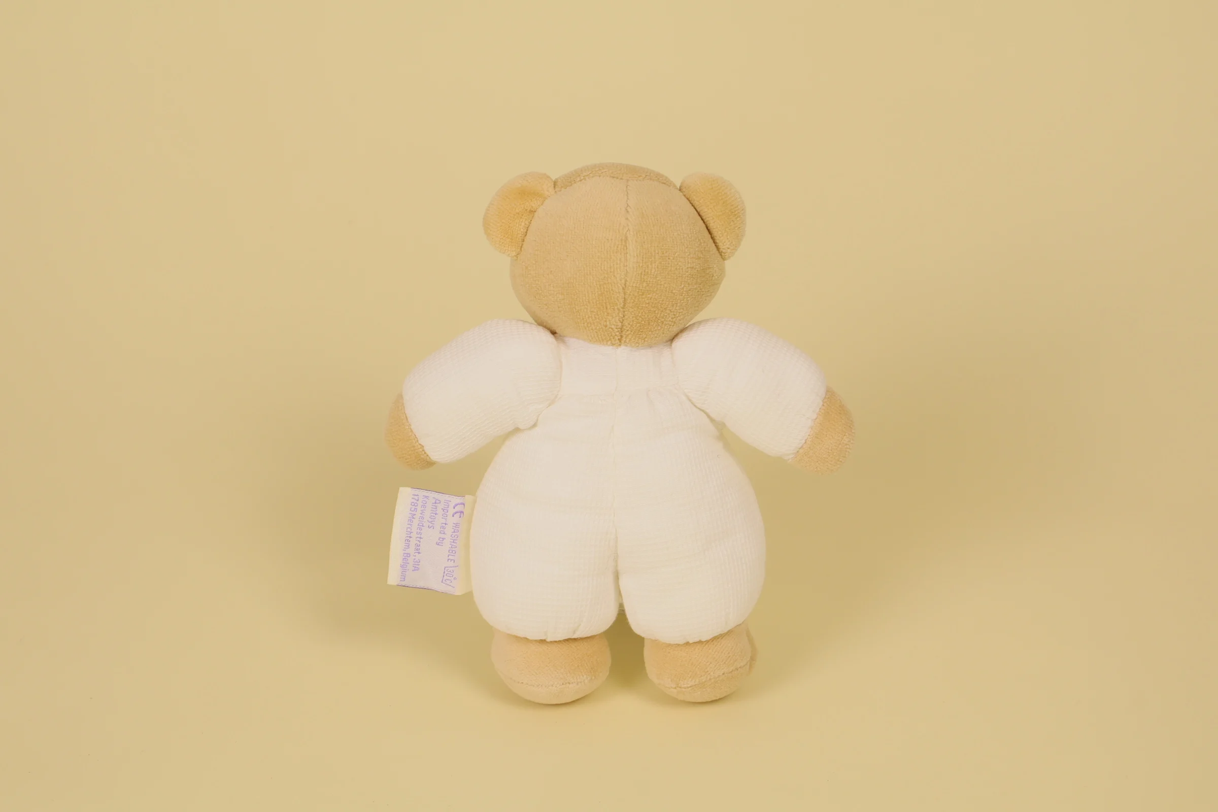 dos Doudou ours beige et blanc avec nœud marron et grelot sonore marque Noukie's