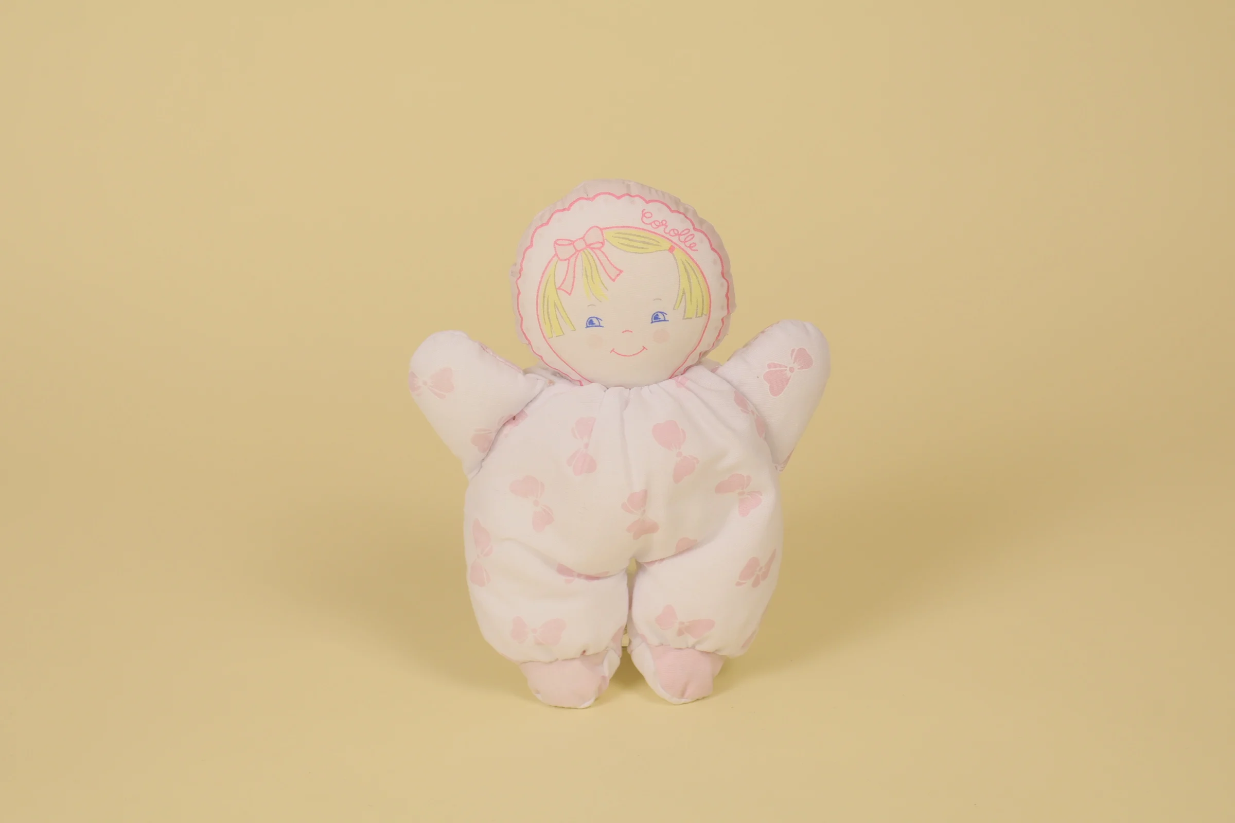 Doudou poupée chiffon blanc imprimé nœuds roses marque Corolle 18 cm