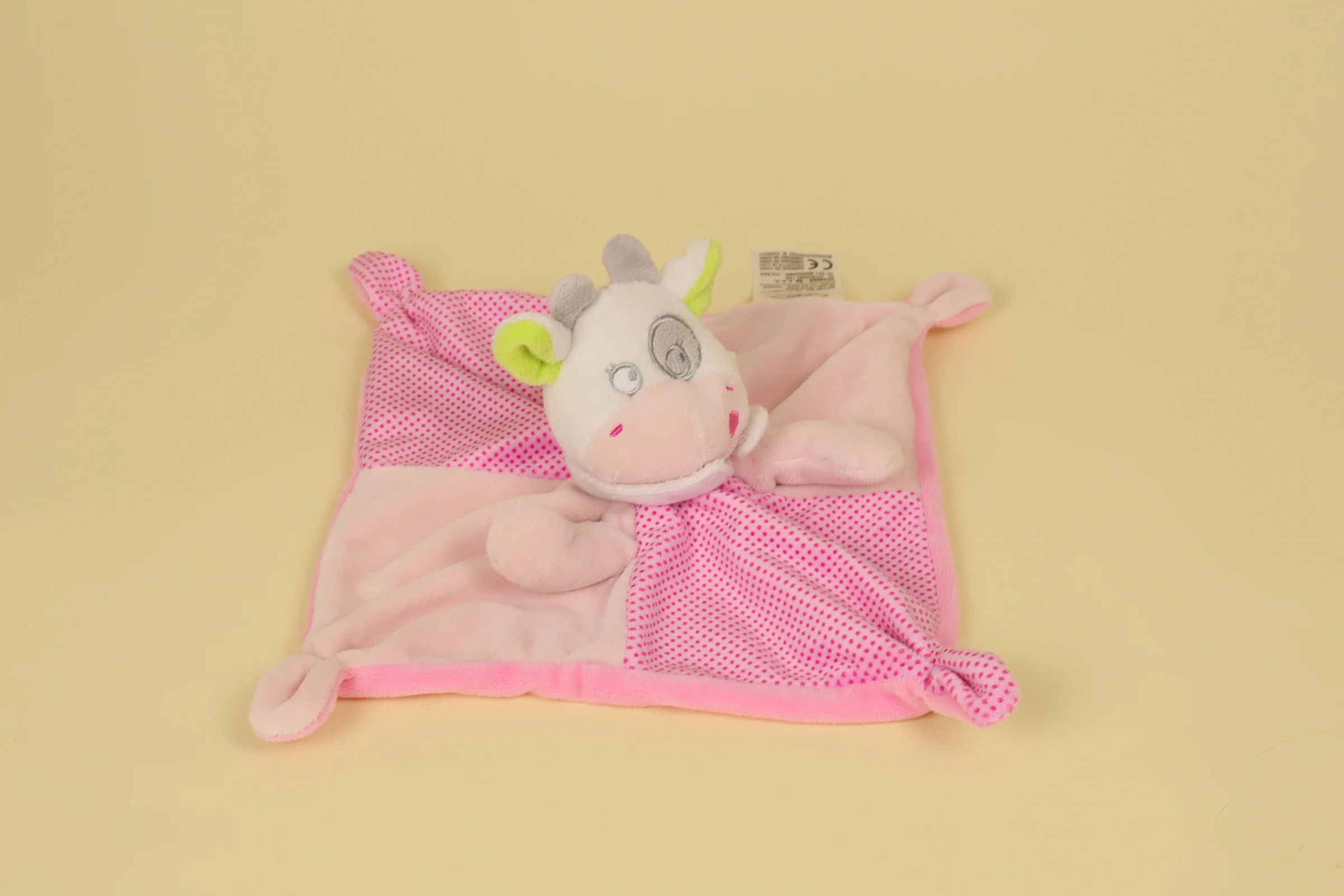 Doudou plat vache rose en deux nuances avec corps mouchoir imprimé à pois et petit bandana autour du cou marque Mots d'Enfants