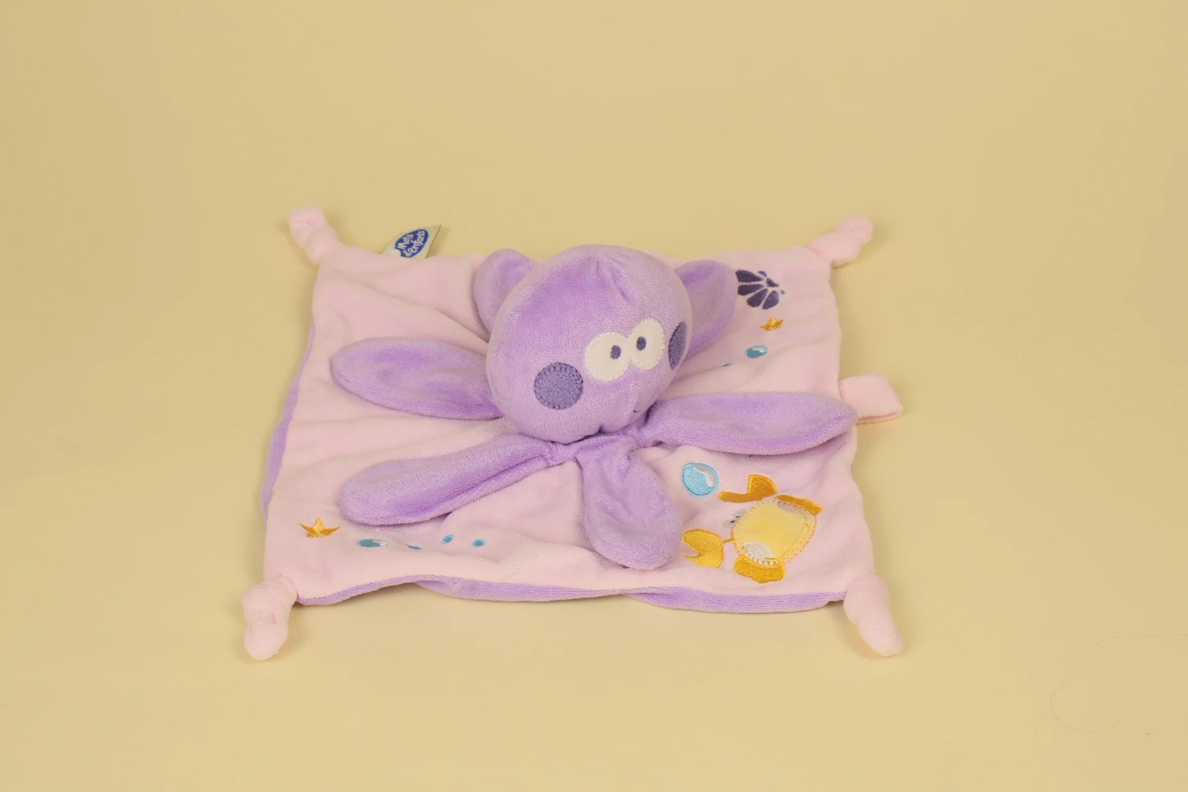 Doudou plat poulpe parme et rose avec corps mouchoir, broderies marines et ruban attache-tétine intégré de la marque Mots d'Enfants