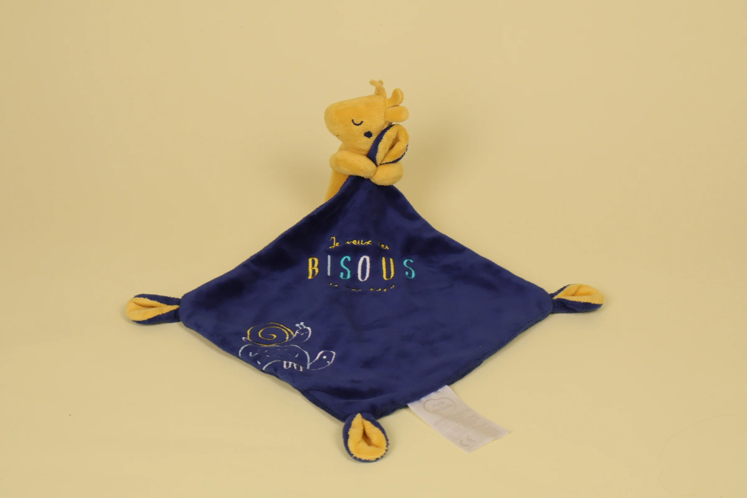 Doudou mouchoir girafe jaune avec corps bleu marine brodé de deux escargots et du texte Je veux des bisous de mon papa marque Mots d'Enfants