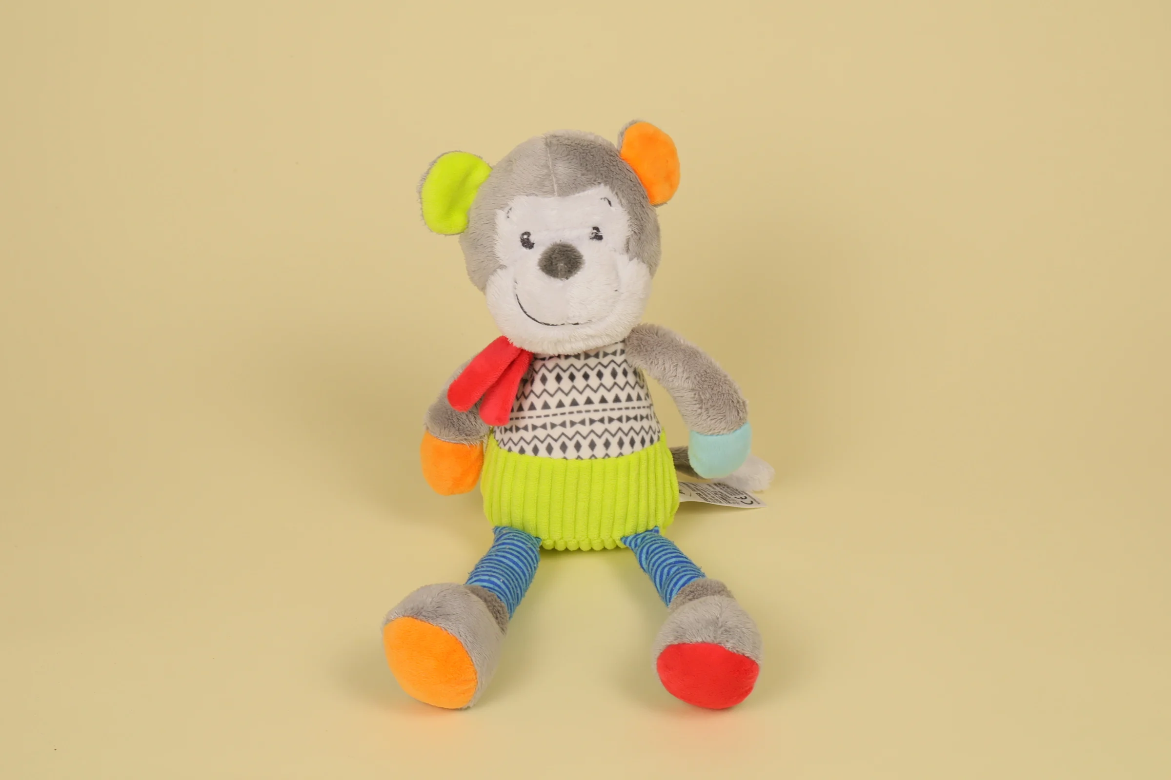 Grande peluche singe de 34 cm aux bras et jambes vert et bleu, corps gris et écharpe rouge autour du cou marque Mots d'Enfants
