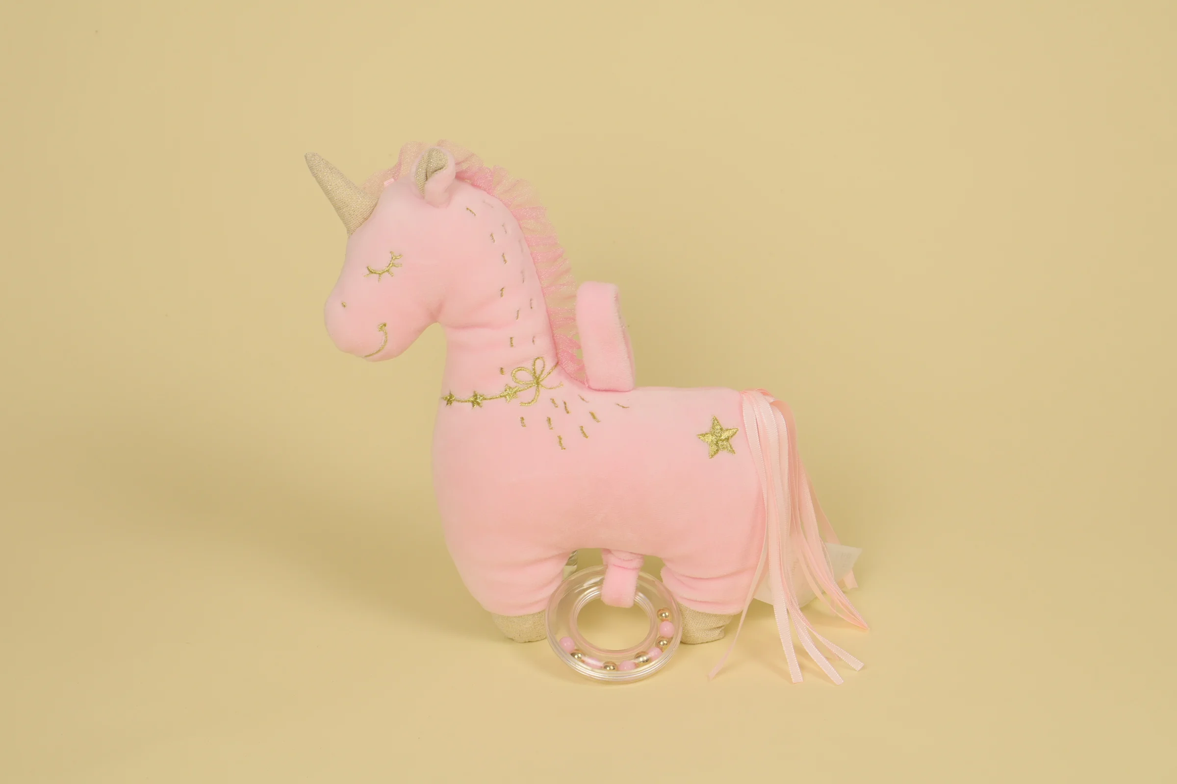 Doudou peluche licorne rose et doré musical avec anneau transparent contenant des billes perles marque Mots d'Enfants