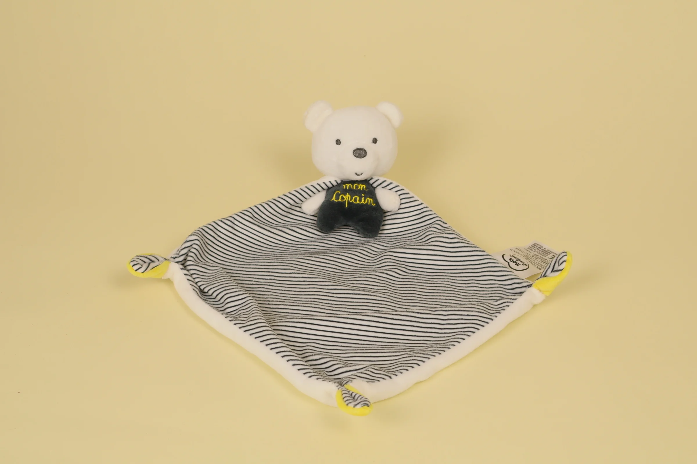 Doudou plat ours en forme de cape blanc rayé noir avec détails jaunes et broderie Mon Copain marque Mots d'Enfants
