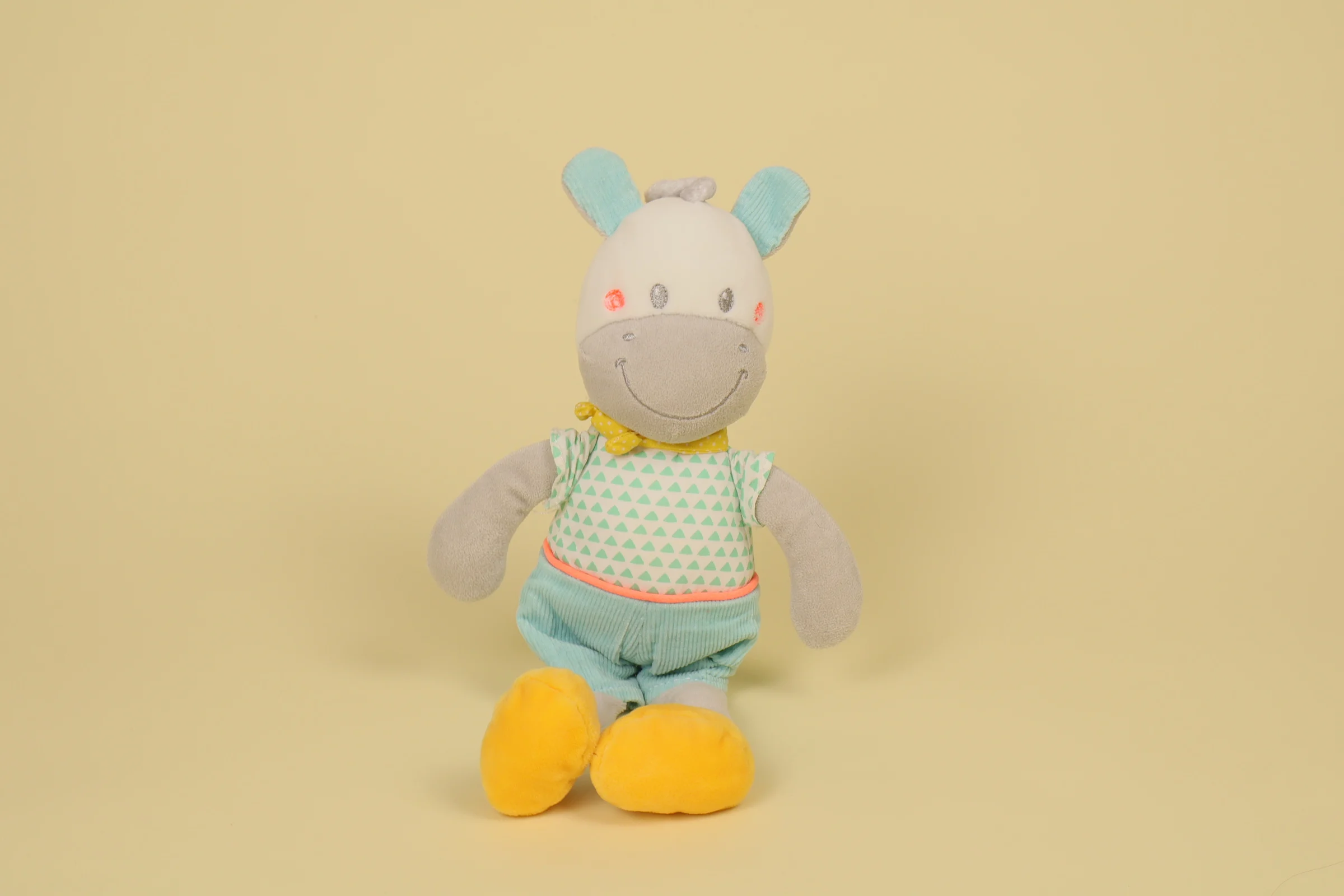Peluche doudou cheval de 30 cm couleur gris bleu portant un t-shirt blanc imprimé de triangles et une écharpe jaune marque Mots d'Enfants