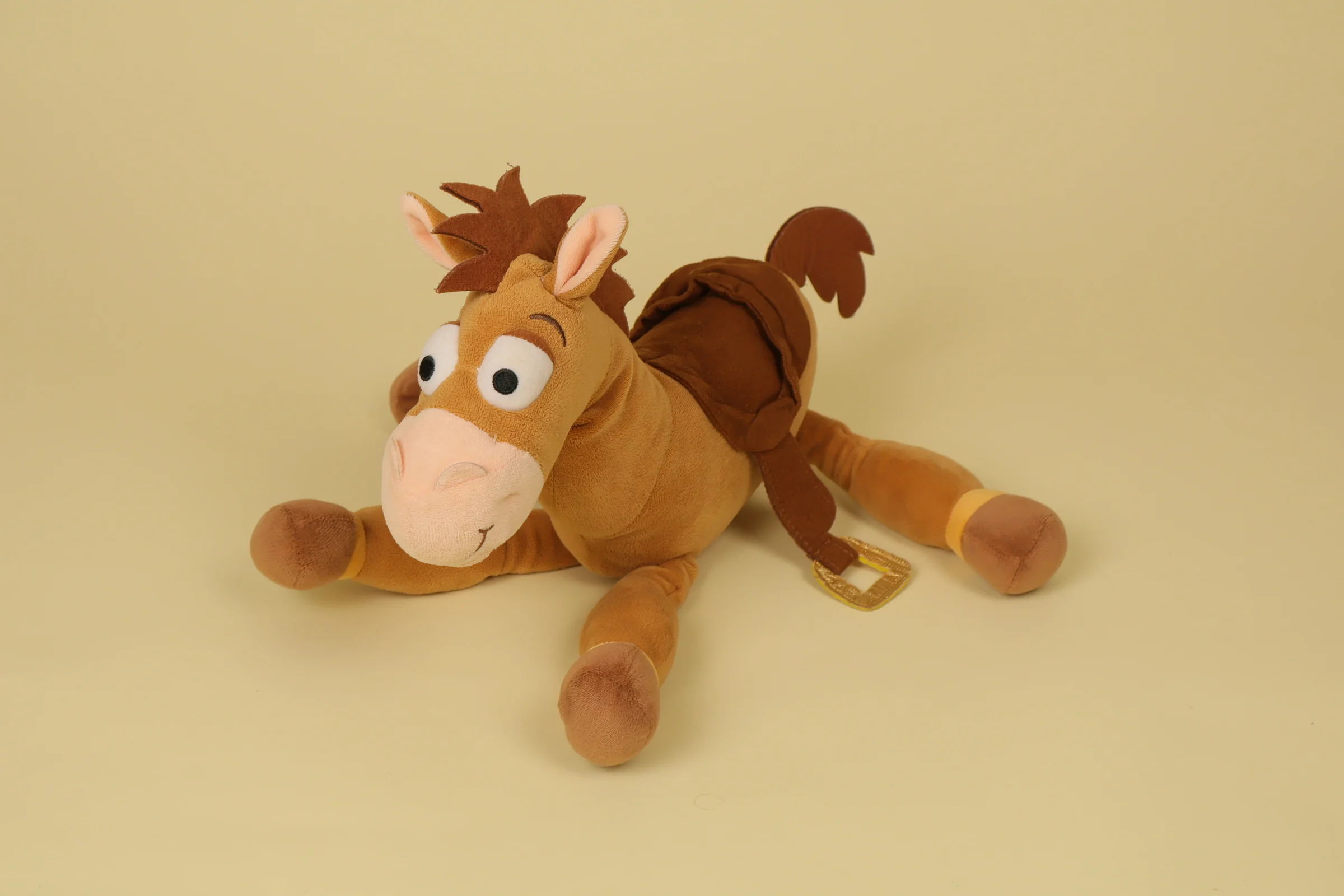 Peluche du cheval Pile Poil de Toy Story mesurant 35 cm de haut de couleur marron avec sa selle et sa crinière de la marque officielle Disneyland