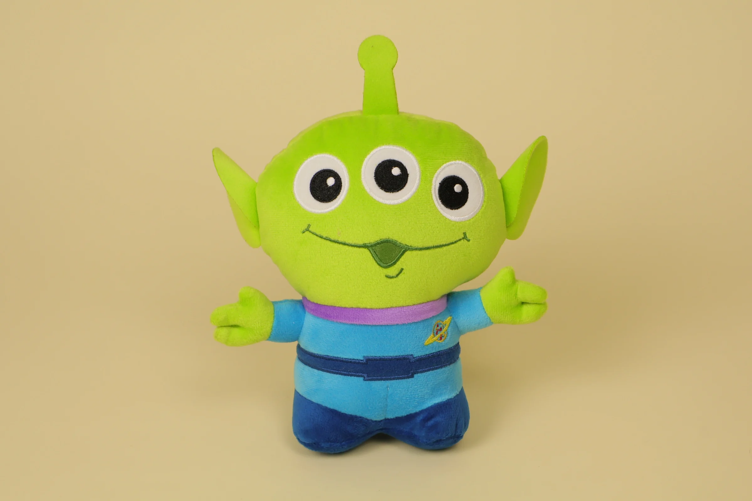 Petite peluche du petit alien vert à trois yeux de Toy Story mesurant 18 cm de haut avec son col mauve et sa tenue bleue marque Disney Pixar