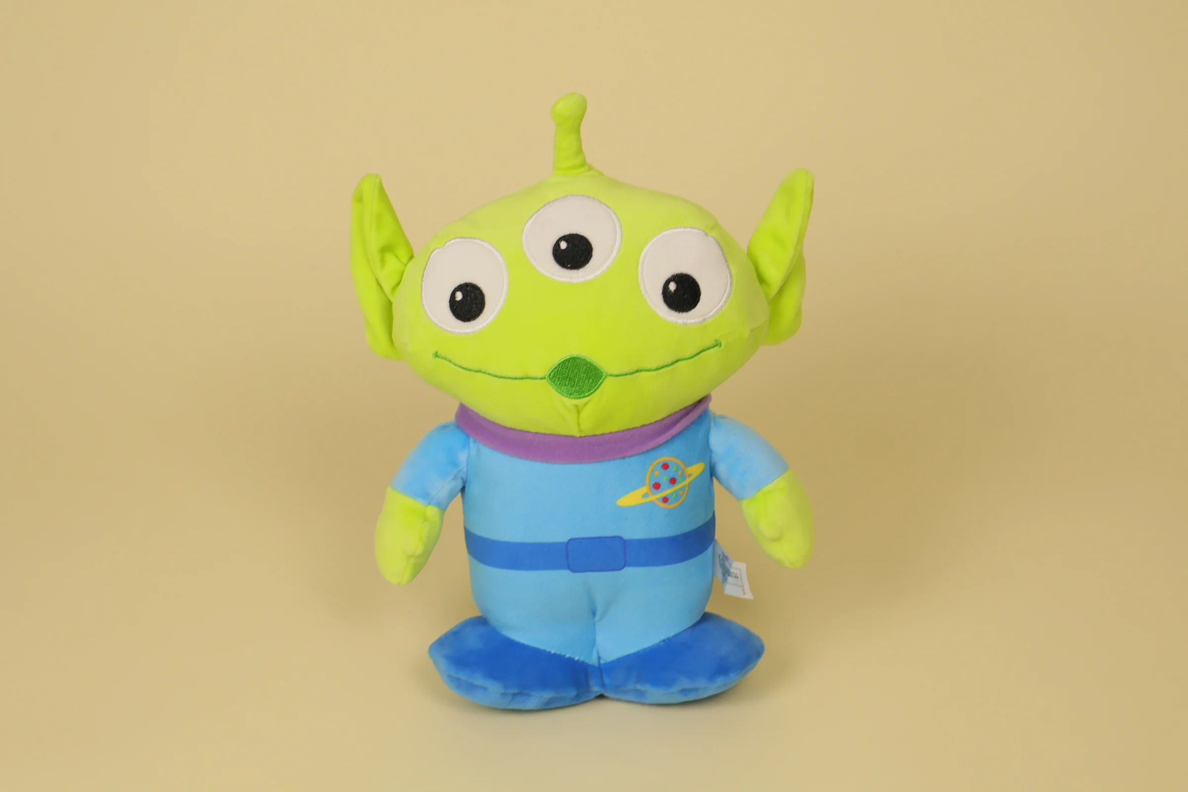 Peluche du petit alien vert à trois yeux de Toy Story mesurant 25 cm de haut avec sa tenue bleue de la marque Disney Nicotoy