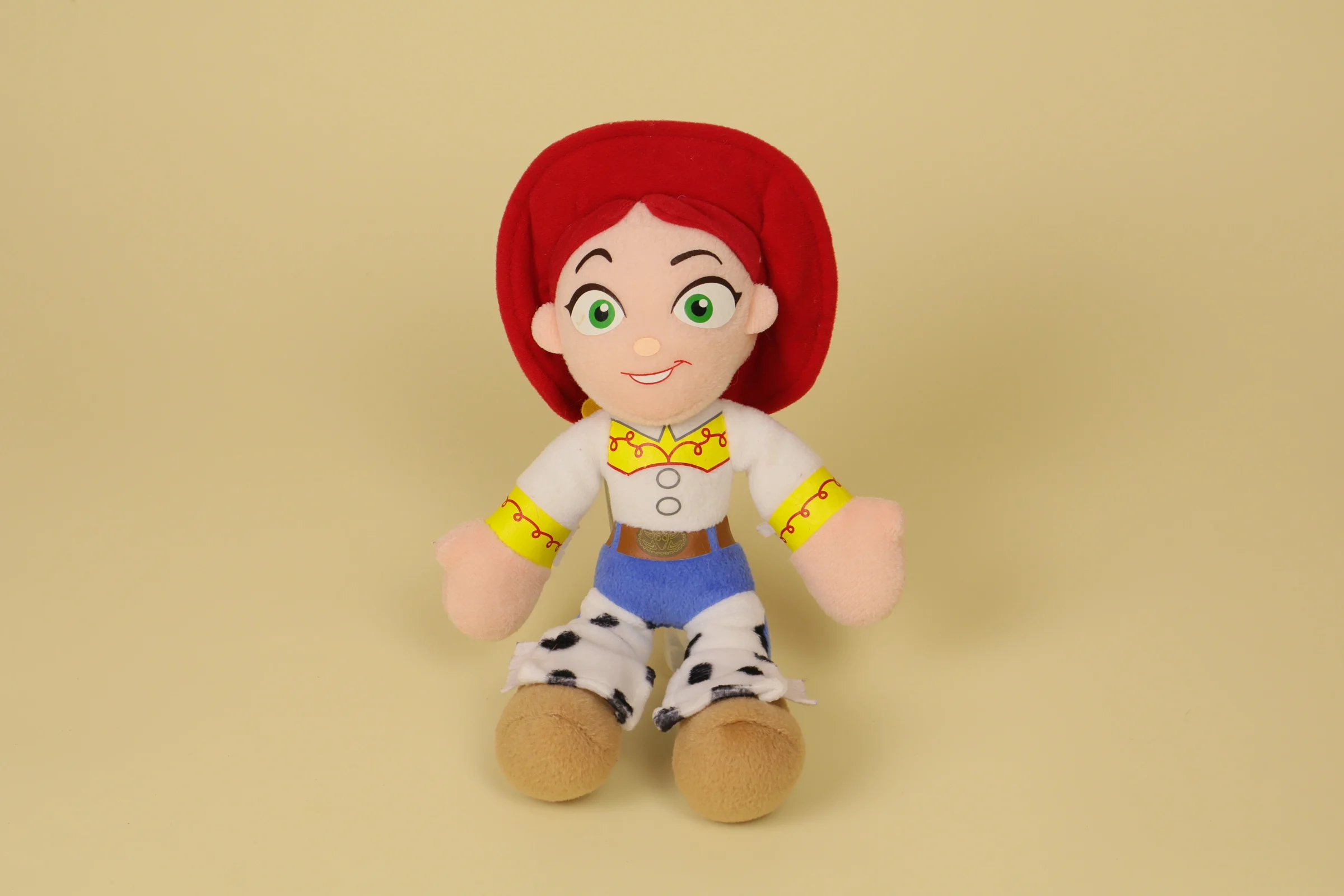 Peluche poupée de chiffon de la cowgirl Jessie de Toy Story mesurant 26 cm de haut avec ses cheveux roux et son chapeau rouge marque Disney Nicotoy"