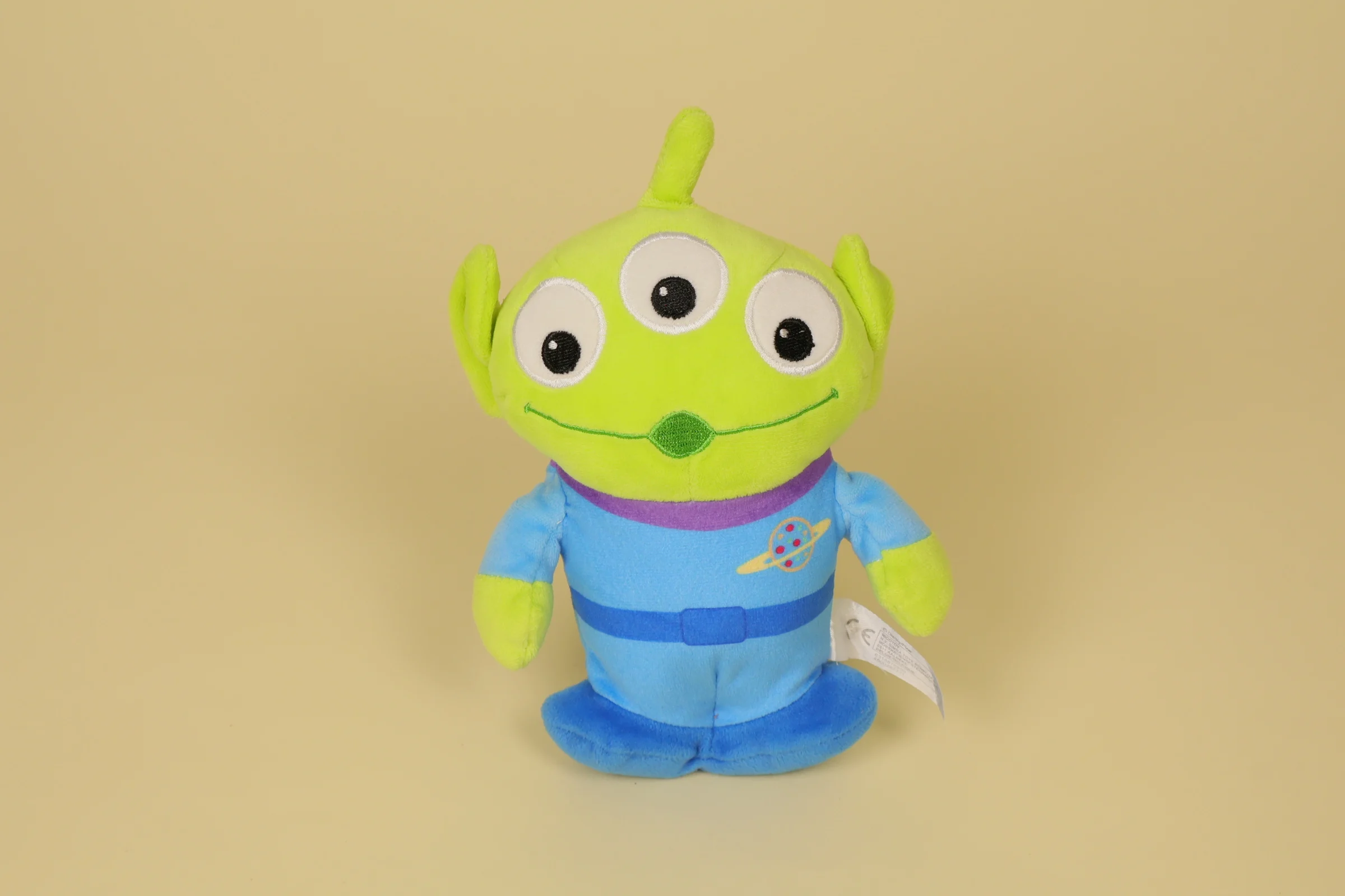 Petite peluche du petit alien vert à trois yeux de Toy Story mesurant 17 cm de haut avec sa tenue bleue de la marque Disney Nicotoy