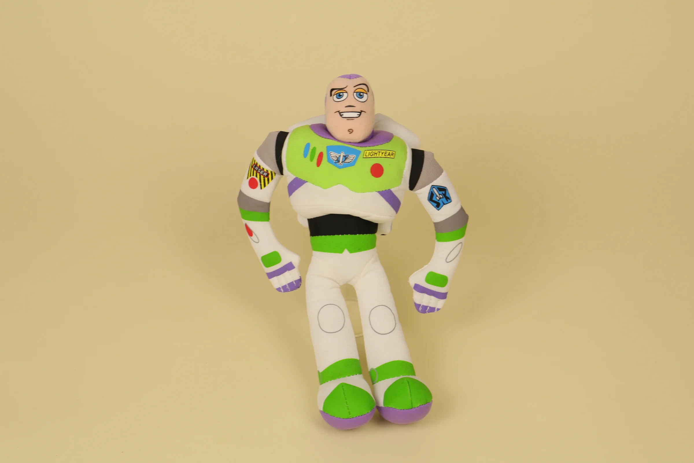 Peluche poupée de chiffon de Buzz l'Éclair de Toy Story mesurant 24 cm de haut avec sa combinaison spatiale blanche, verte et violette de la marque officielle Disney