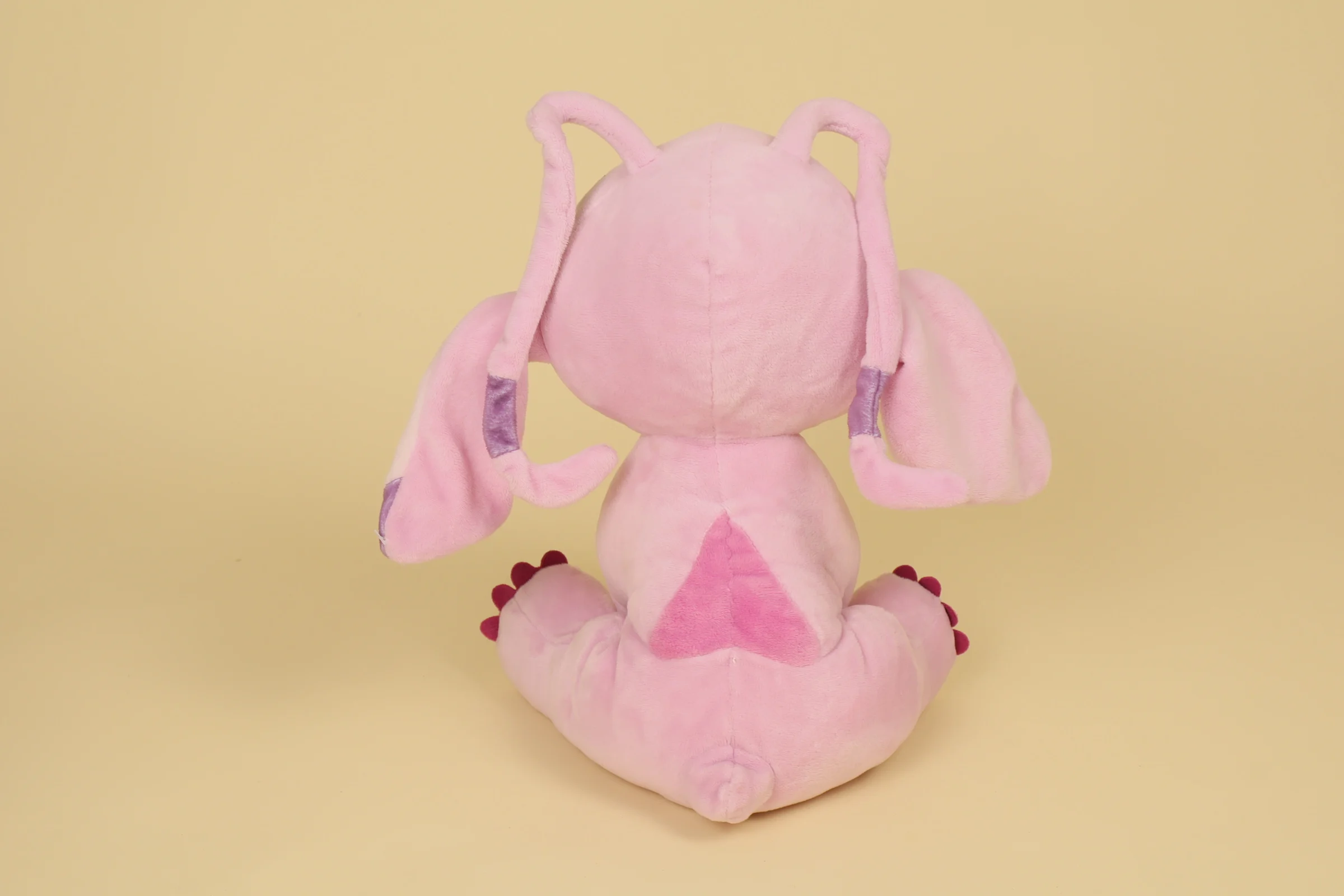 dos Peluche Angel rose clair mesurant 29 cm de la marque Disney Play by Play