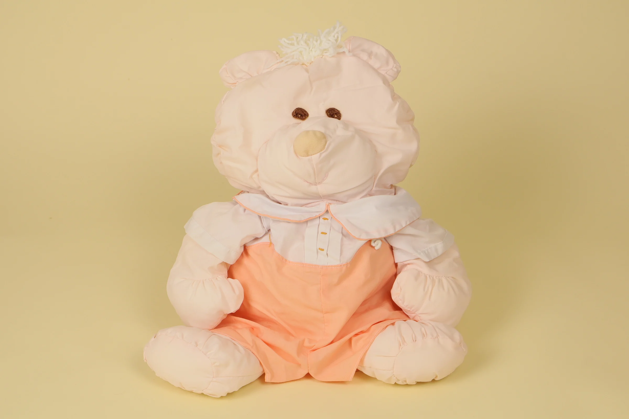 Grande peluche ours rose saumon et blanc style Puffalump en coton portant une salopette mesurant 39 cm de haut