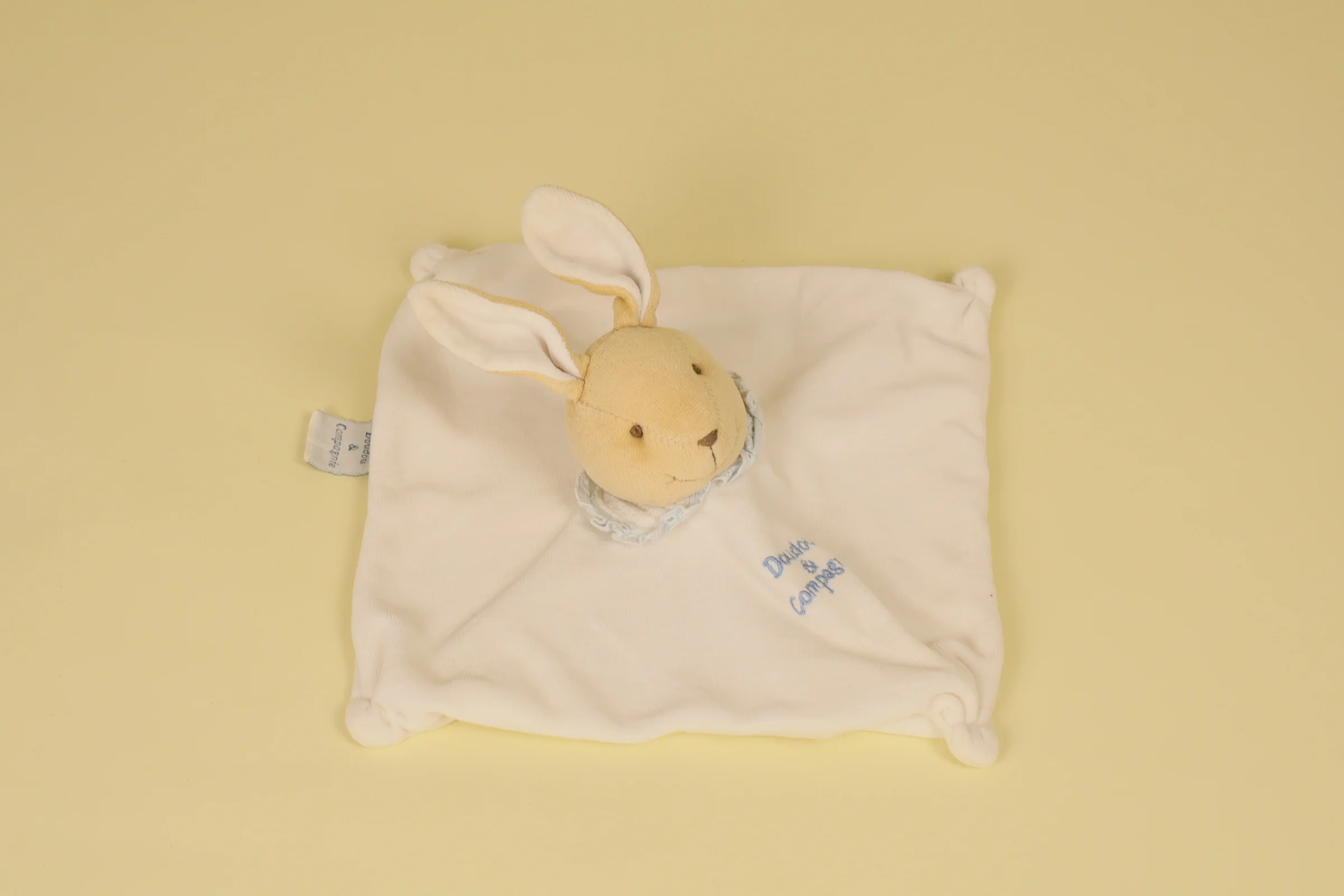 Doudou Lapin plat blanc avec col dentelle bleu et broderie assortie collection L'original 2000 marque Doudou et Compagnie