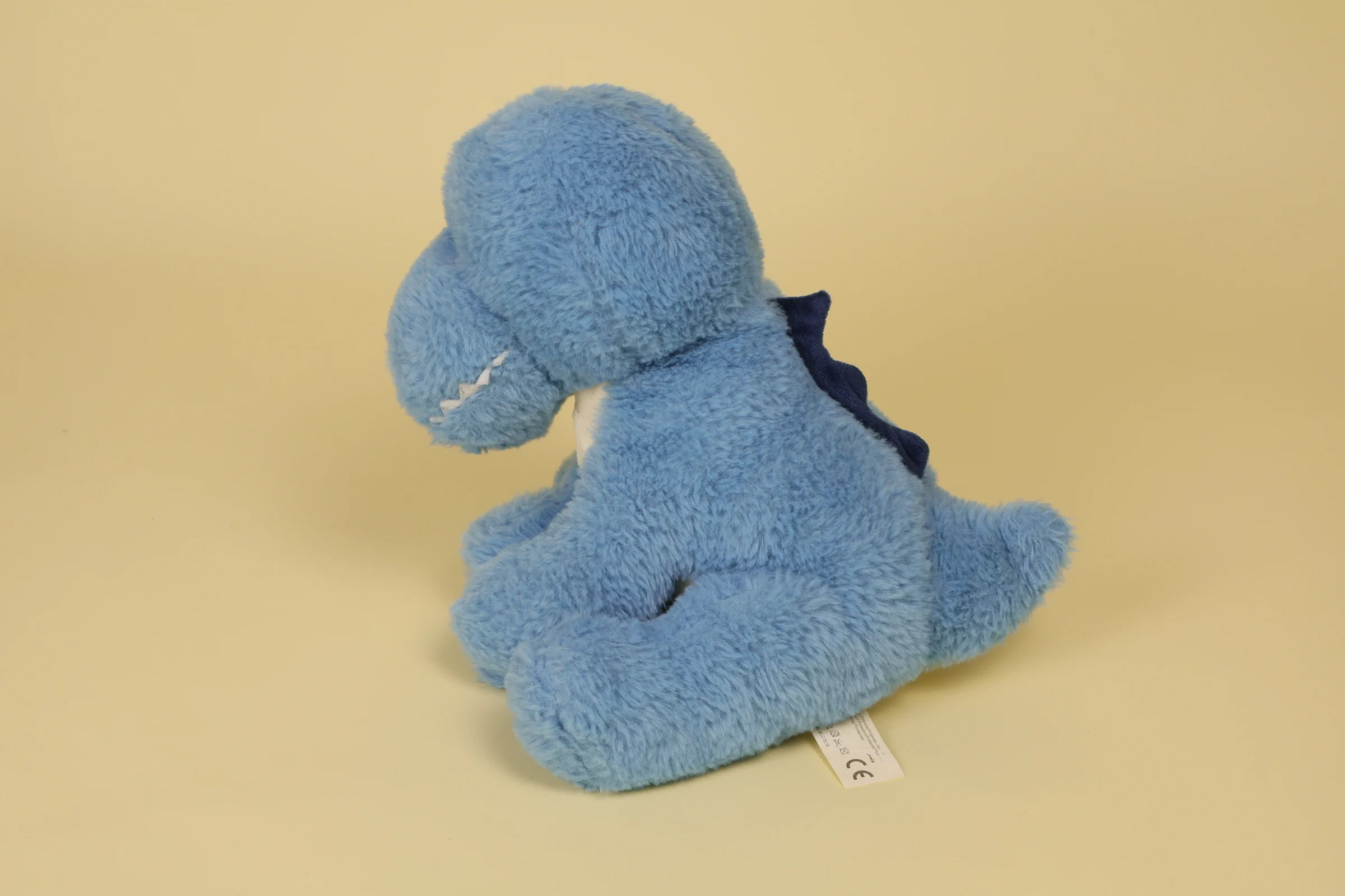 Peluche Dinosaure T-Rex Bleu avec ses Cretes Dorsales Bleues Foncees et ses Dents en Feutrine 27 cm Annee 2019 2021 Marque Auchan profil