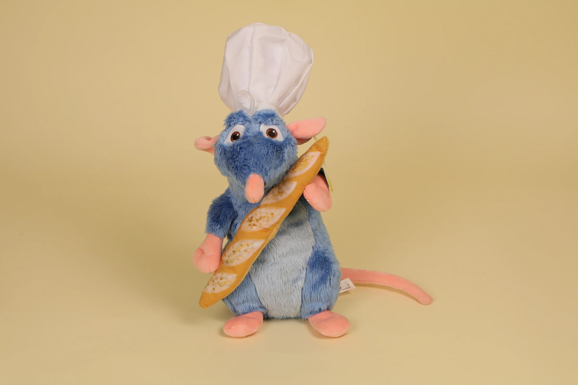 Peluche Rat Remy tenant son pain et portant une toque du film d animation Ratatouille Mesure 34 cm avec sa toque Annee 2018 Marque DISNEY